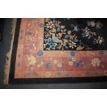 A Chinese wool carpet with central floral medallion and pattern of butterflies and floral sprays
