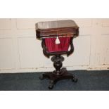 A Victorian rosewood sewing / work table with lifting rectangular top with canted corners, enclosing
