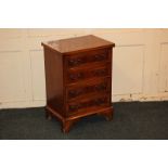 A small inlaid yew wood chest of four drawers, with rectangular cross-banded top, on shaped