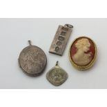 A shell cameo brooch in gilt mount, a silver locket, a silver ingot, and a Victorian St Christopher