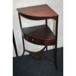 A George III mahogany bow-front washstand with central drawers, splayed legs, and platform