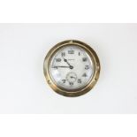 A Swiss made brass cased car clock, the dial with Arabic numerals and subsidiary seconds dial,