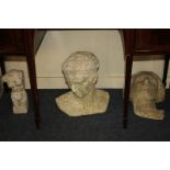 Three composition garden ornaments comprising the head of a Greek warrior, the head of Aphrodite,