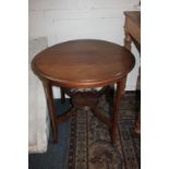 An Edwardian inlaid mahogany circular side table on four curved legs with platform stretcher, 61cm