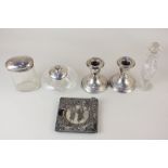 A pair of George V silver dwarf candlesticks, two silver lidded cut glass dressing table jars, a