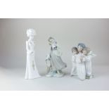 A Lladro model of a girl with two doves, 22cm, together with a Lladro figure group of three winged