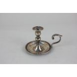 A Victorian silver taper stick with baluster stem, circular base and scroll handle, London 1872