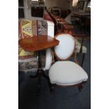 A Victorian low chair with oval back and seat, with turned support and fluted legs and castors (