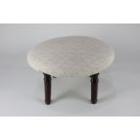 An early 19th century footstool, the oval upholstered seat on four mahogany shaped legs