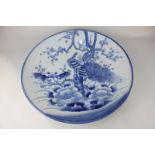 A Japanese porcelain blue and white charger depicting a bird in a tree, with nine firing points to