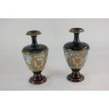 A pair of Royal Doulton pottery baluster vases with floral and gilt design, 18cm high