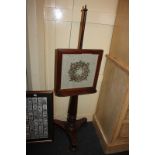 A Victorian mahogany adjustable fire screen, with glazed needlework panel on pole and turned wood
