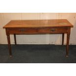 An oak school table with rectangular plank top and two drawers with brass drop handles, on