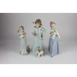 A Lladro porcelain figure of a girl with kittens, two Nao porcelain figures, a lady with fan, and