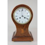 A Victorian oak cased balloon mantel clock with shell inlay, the white enamelled dial with Roman