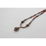A silver mounted amber necklace with heart shaped pendant