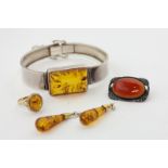 A silver and amber bangle, a 9ct gold and amber ring, a pair of drop earrings, and a silver and