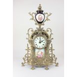 A brass and porcelain mantel clock, the white enamel dial with Roman numerals, marked Imperial, made