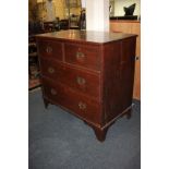 An 18th century country oak chest of two over three drawers, brass drop handles and shaped