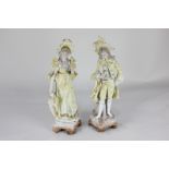 A pair of Continental bisque porcelain figures of a lady and a gallant, both dressed in yellow