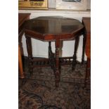An octagonal mahogany occasional table on turned supports with uniting X frame stretcher and ceramic