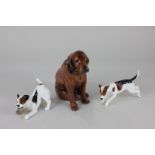 A Royal Doulton porcelain model of a hound dog (HN976), together with two models of terriers (a/f)