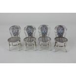 A set of four Chinese white metal miniature models of cloisonné chairs with floral design against