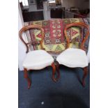 A pair of balloon back chairs with scroll carved back bars, on cabriole legs