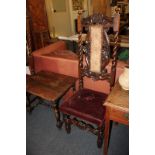 A pair of Carolean style carved oak high back chairs, with scroll panel back, turned uprights and
