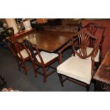 Three Sheraton style mahogany dining chairs including one carver, and another carver with shield