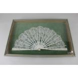 A 19th century lace fan with sequinned floral design, in glazed case