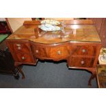 An early 20th century walnut dressing table with central bow drawer flanked by two pairs of