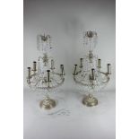 A pair of ornate candelabra table lamps with cut glass droplets on glass and silverised embossed