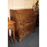 A George III mahogany bureau with fall enclosing fitted interior above four drawers, on bracket feet