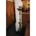 A Victorian cast iron oil standard lamp with white glass globular shade, on adjustable scrolling