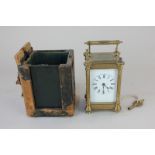 A gilt brass and bevelled glass cased carriage clock, the case with floral design, in leather