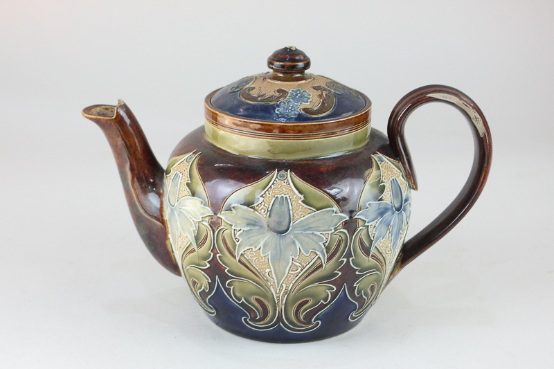 A Doulton Lambeth pottery teapot by Eliza Simmance, decorated with stylized daffodils, incised