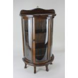 A mahogany bow fronted glazed table-top cabinet with door enclosing two shelves, 58cm high