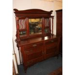 An Art Nouveau mahogany sideboard with bevelled glass mirror back, with two short drawers over two