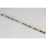 An unusual glass tube containing stripes of coloured thread, 47cm long