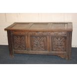 A three panel oak coffer, the front carved with foliate designs, on bracket feet, 135cm