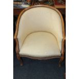 A French style tub chair with yellow upholstered studded back and seat, on cabriole front legs