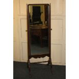 A mahogany framed cheval mirror, tapered supports with brass vase finials on curved legs with hoof