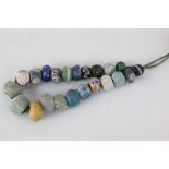 A string of coloured pottery beads, bearing a label stating '22 ancient paste beads found in the