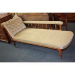 A Victorian chaise longue, with button upholstered back, padded back rail on spindle supports, on