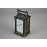 A brass carriage clock, with white enamel dial and Roman numerals, 14.5cm high