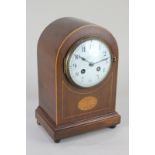 An Edwardian mahogany dome mantel clock the circular dial with Arabic numerals, the French