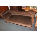 A chaise longue with scroll end and button back, brown upholstery, on turned legs and brass castors