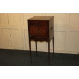 A 19th century mahogany pot cupboard, with brass side handles and two doors on slender tapered