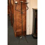 A wrought iron three branch candle stand 137cm high